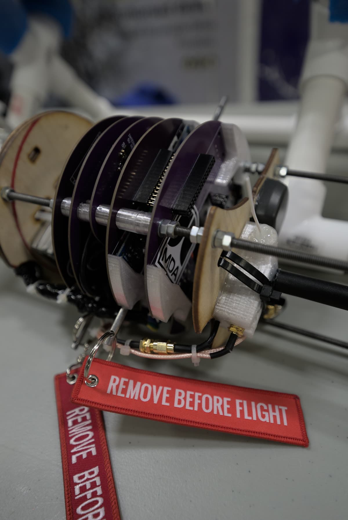Custom avionics stack of circular PCBs with a remove-before-flight tag