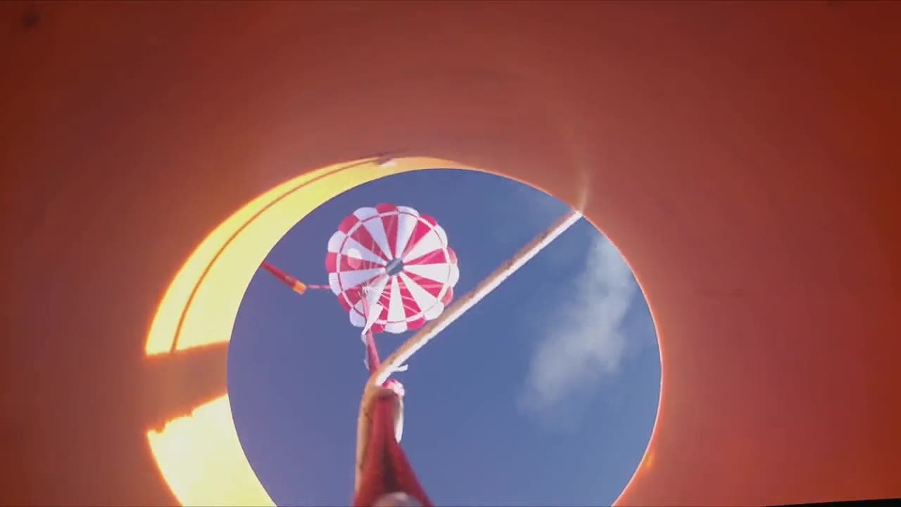 Onboard view of the parachute deploying against a blue sky