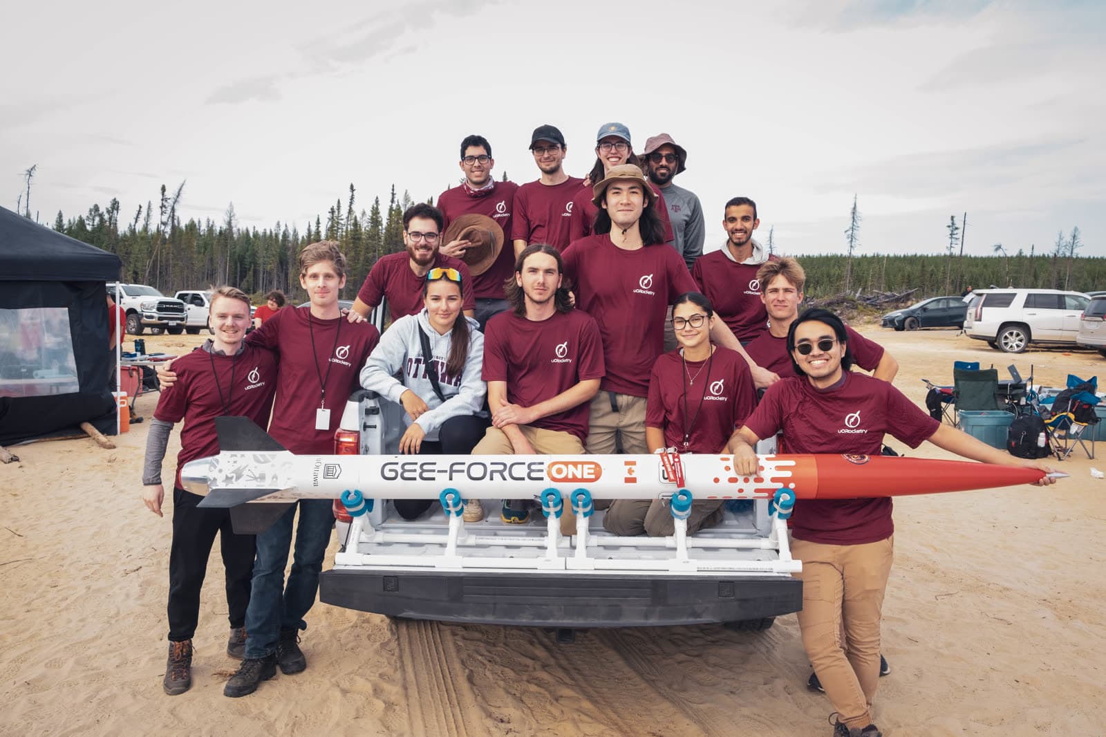 The uOttawa Rocketry team posing around the rocket on a truck bed